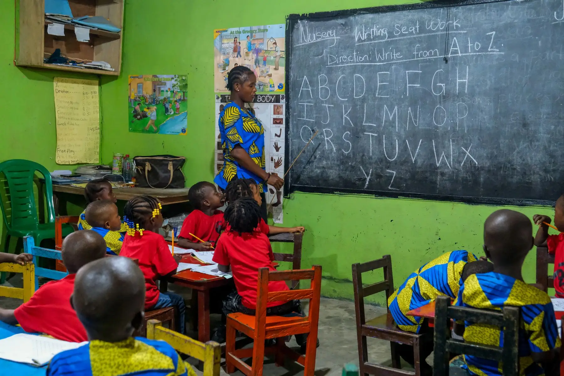 A teacher at the blackboard leading a lesson in an East African primary classroom
